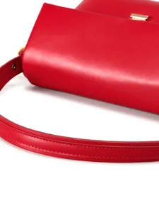 Red leather shoulder bag detail shot showcasing smooth texture and exquisite gold hardware clasp.