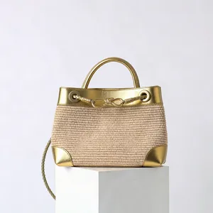 Sac à main en paille d'été pour femme, bordure métallique dorée et poignée avec nœud.
