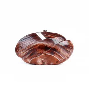 Detailed view of the stylish brown wave acrylic clutch bag with exquisite metal clasp hardware.