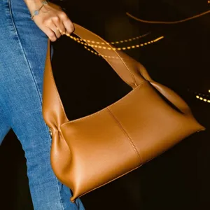 Brown leather hobo shoulder bag for women, stylish French croissant underarm bag with long handle.