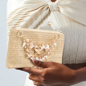 Chic straw woven clutch bag with pearls and shells for women summer beach vacation style.