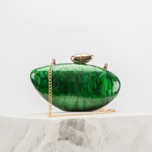 Green marble acrylic clutch purse detail showing gold chain strap and metal clasp closure.