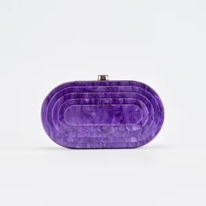 Close-up detail of purple marble acrylic evening clutch, glossy hard shell surface finish.