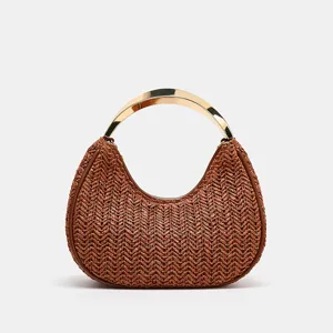 Brown woven crescent handbag detail, featuring a sleek metallic arch handle for chic style.