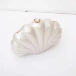 Pearl white shell clutch bag detail, acrylic evening purse with metal clasp closure.