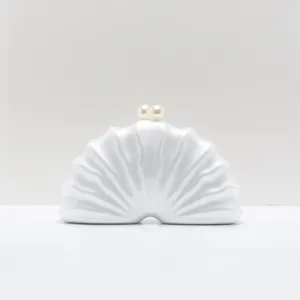 Detail view of white acrylic shell clutch with dual pearl clasp for women evening party.