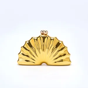 Golden shell shaped evening clutch bag detail view showcasing smooth glossy metallic finish.
