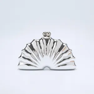 Silver shell clutch bag detail, metallic evening party purse, exquisite clasp closure close up.