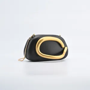 Elegant black leather evening box bag with striking gold sculptural handle and chain.
