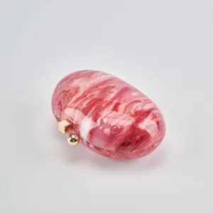 Pink marble acrylic oval evening clutch bag with gold tone metal clasp detail close-up.