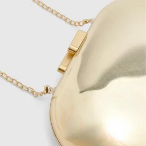Gros plan detail de la pochette rigide en acrylique doree avec chaine metal et fermoir elegant.