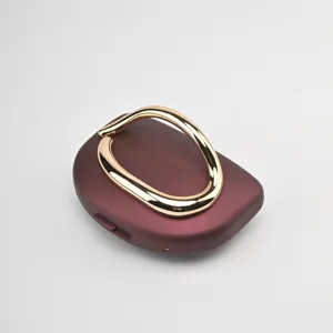 Élégante pochette de soirée bordeaux avec poignée sculpturale dorée pour style chic.