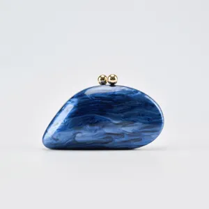 Detailed view of the blue marble acrylic clutch purse with gold sphere clasp for evening parties.