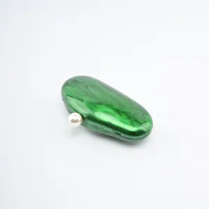 Green acrylic clutch bag detail showing marble pattern and elegant pearl clasp design.