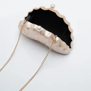 Acrylic shell clutch bag with pearl clasp and gold chain for evening party and wedding.