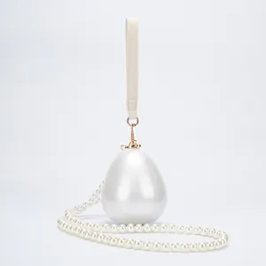 Sac pochette ovale en perle acrylique avec dragonne en cuir et chaine de perles.