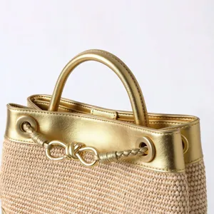Sac à main chic en paille tissée avec bordure en cuir doré et élégante quincaillerie.
