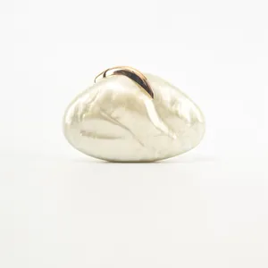 Close-up detail shot of luxury white marble pattern acrylic evening clutch with elegant gold leaf clasp.