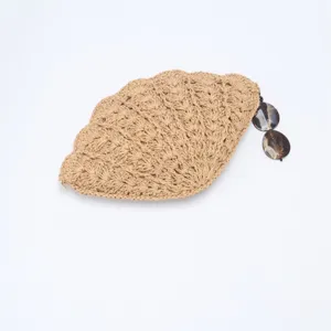Chic shell-shaped straw woven crossbody bag, hollow design, perfect for beach vacation.