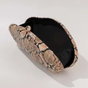 Vue détaillée de la texture et du fermoir de la pochette de soirée imprimé serpent.