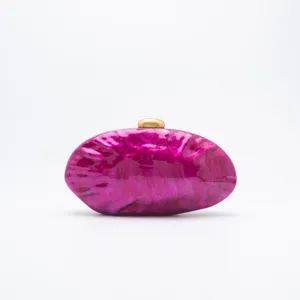 Glossy magenta marbled acrylic clutch bag detail showing exquisite gold-tone metal clasp.