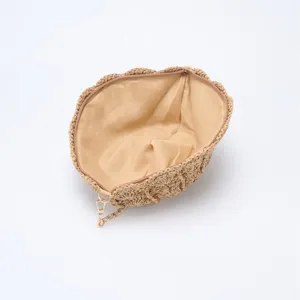 Detailed interior view of the straw woven shell crossbody bag, featuring smooth lining and zipper.