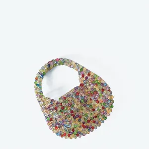 Detail shot of handcrafted colorful beaded mini handbag close-up, glittering crystal bead weave