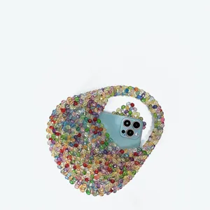 Handmade colorful beaded mini handbag detailed view showing capacity with a smartphone.