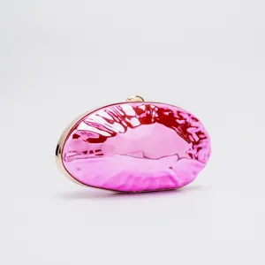 Close-up of glossy pink acrylic evening clutch bag with gold-tone metal frame and clasp detail.