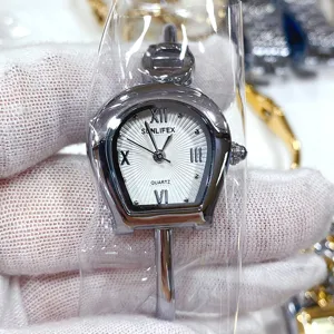 Détail montre quartz style équestre, cadran blanc avec chiffres romains et bracelet métal.