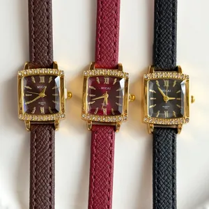 Close-up of vintage women quartz watch with rhinestones, square gold case and leather strap.