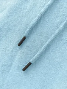 Primo piano del tessuto per abbigliamento azzurro con coulisse intrecciate e punte nere.
