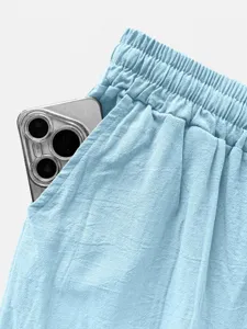 Primo piano della cintura e della tasca di pantaloni casual azzurri con trama in tessuto.