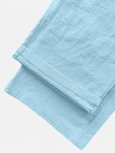 Primo piano di pantaloni casual azzurri che mostra una trama fine e dettagli dei risvolti.