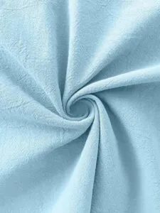 Primo piano sulla texture del tessuto azzurro, dettaglio del materiale per abbigliamento.