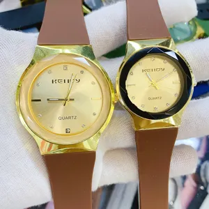 Vintage minimalist couple watch with brown silicone strap and gold dial detail shot.