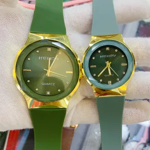 Minimalist quartz couple watch with green silicone strap and luxury gold round dial.