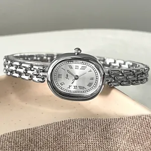 Silberne ovale Uhrendetailansicht mit retro römischem Zifferblatt und filigranem Metallarmband.
