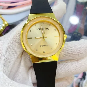 Vintage minimalist quartz watch with black silicone strap and gold round dial details.
