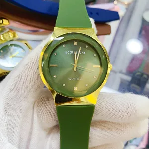Close-up detail of green and gold quartz watch with silicone strap and rhinestone dial markers.