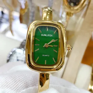 Close-up detail of green dial square quartz watch with gold metal case and bangle strap.