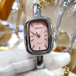 Closeup view of a square pink dial quartz bangle watch with polished silver metal strap.