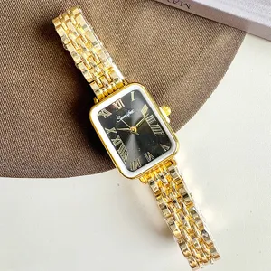 Dettaglio di orologio al quarzo rettangolare dorato, quadrante nero con numeri romani.