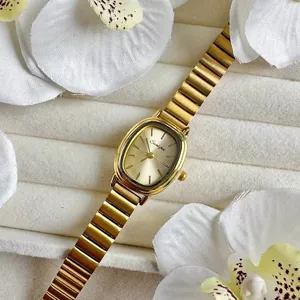 Nahaufnahme der eleganten goldenen ovalen Damenuhr mit Bambusgliederarmband und Zifferblatt.