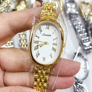 Gros plan détail de montre quartz ovale dorée pour femme avec cadran blanc et chiffres romains.