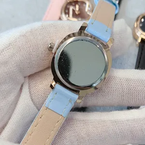 Vue détaillée de la montre femme avec bracelet en cuir clair et fond de boîtier en métal.