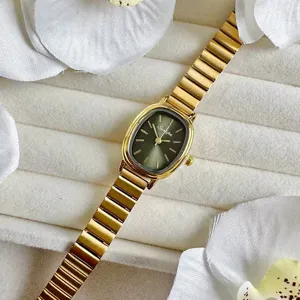 Nahaufnahme der eleganten goldenen ovalen Quarzuhr mit glattem stilvollem Bambus-Metallarmband.