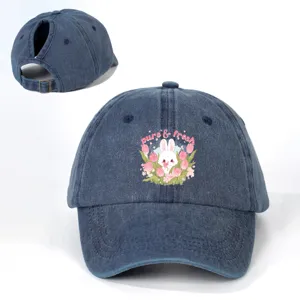 Distressed denim ponytail baseball cap with cute bunny and tulip print, adjustable back strap.