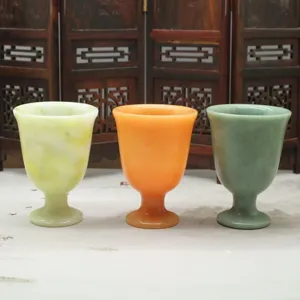 Detailansicht von Naturjadekelchen, die drei bunte Steingläser im traditionellen Stil zeigen.