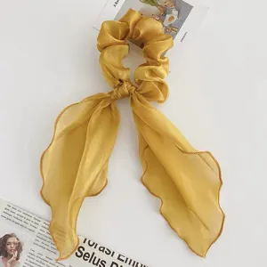 Chouchou de cheveux en organza jaune avec longs rubans, tissu brillant et beau style drapé.